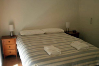 Bedroom 1 with queen sized bed, lamps and bedside drawers.