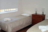 Bedroom two with 2 single beds, lamps and bedside drawers